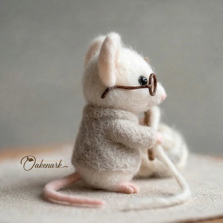 Felted mouse toy with glasses on a neutral background