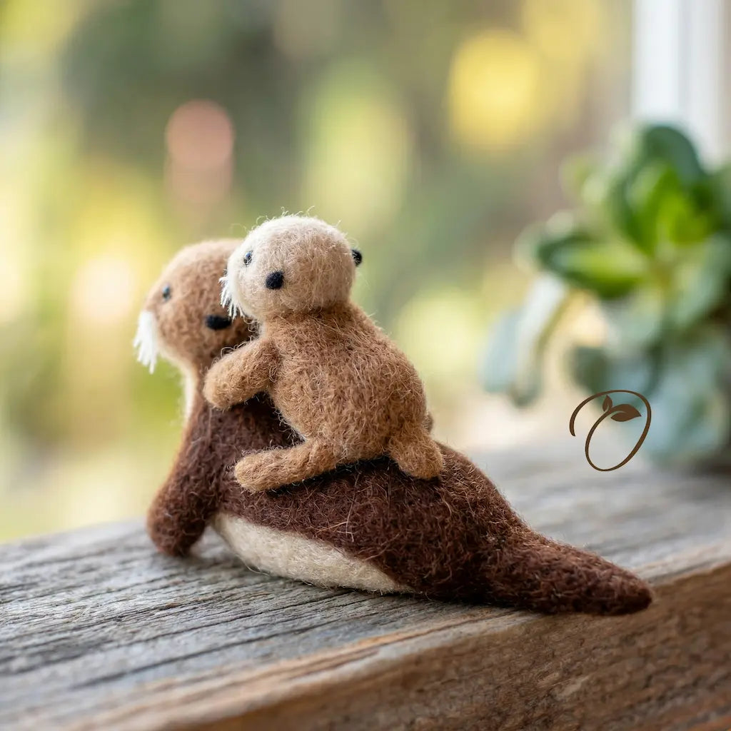 Two plush otters sitting on a wooden surface with a blurred natural background