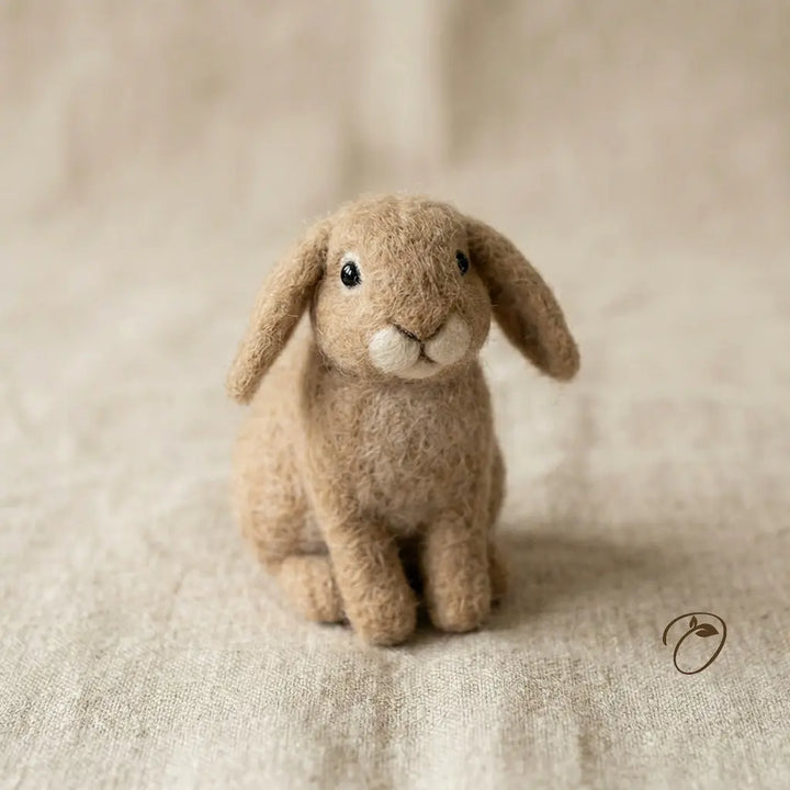 Brown plush rabbit toy on a textured beige surface