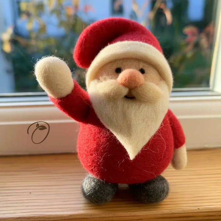 Front view of a wool felt Santa figurine waving a cream mitten, with a folded red hat, ivory beard and gray boots.