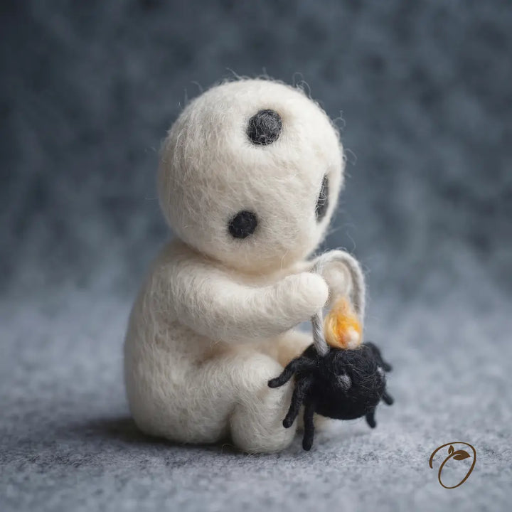 Side view of Lantern Sprite felt figurine showing its seated pose, curved arms and spider lantern