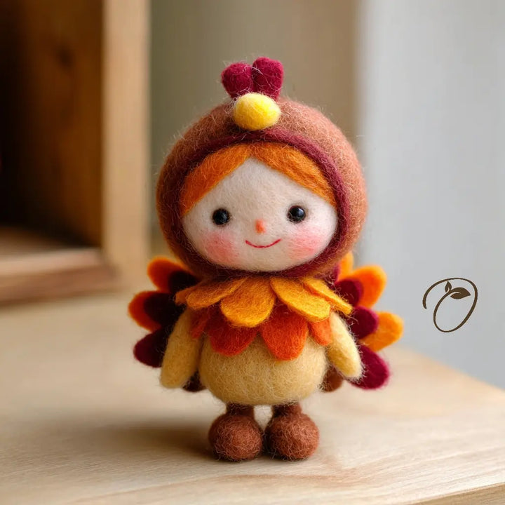 Front view of a wool felt turkey sprite with a smiling face, orange hair, a brown hood, and layered golden and orange ruffles.