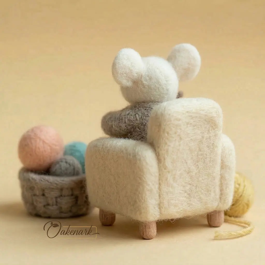 Fuzzy chair with a bear head design, surrounded by yarn balls on a beige background