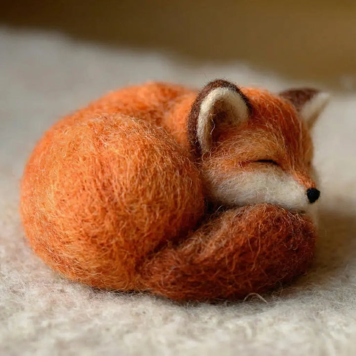 Sleeping fox plush toy on a soft surface