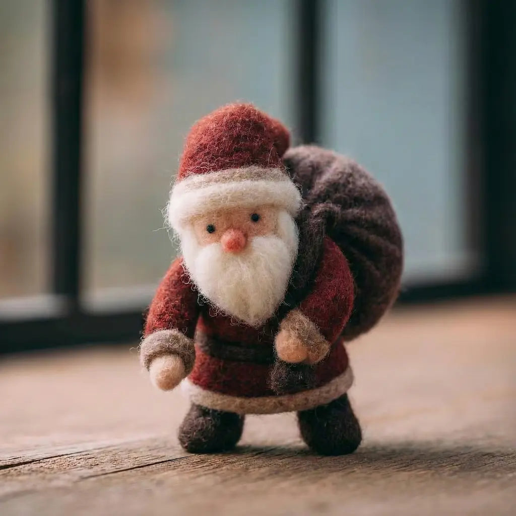Small felt Santa Claus figure on a wooden surface with a blurred background
