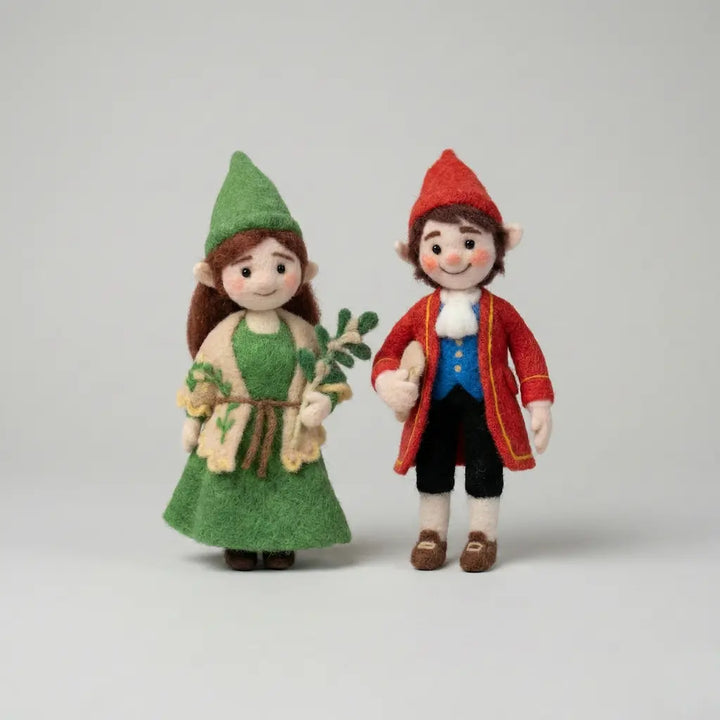 Two toy elves, one in green and one in red, standing side by side on a light gray background.