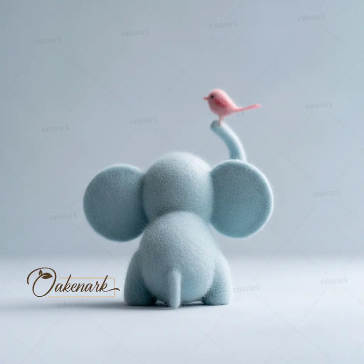 Blue elephant figurine with a pink bird on its trunk against a light gray background, featuring the Oakenark brand.