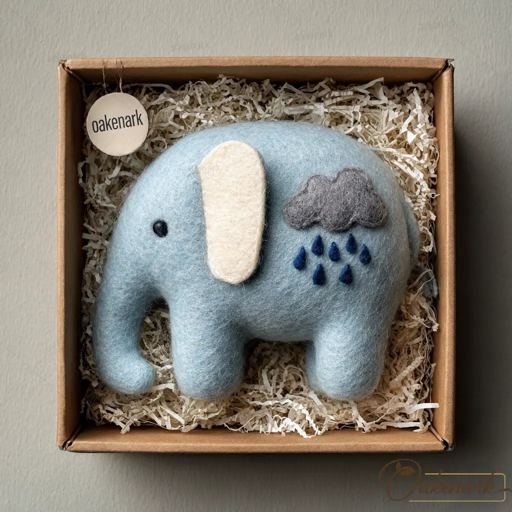 Blue elephant plush toy with cloud and raindrop details in a box labeled 'oakenark'.