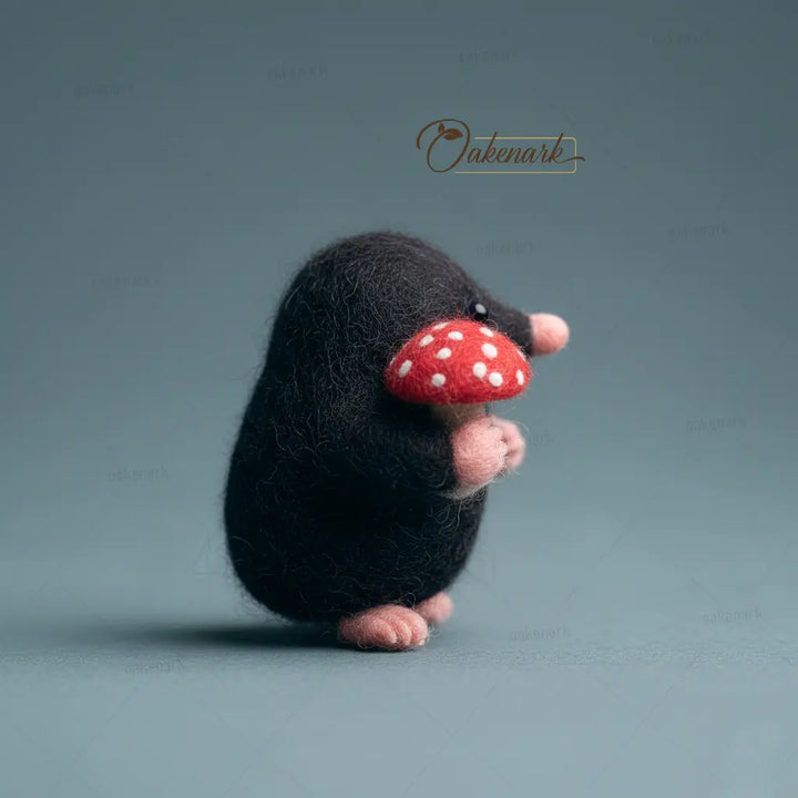 Small plush toy mole with a red mushroom on a gray background