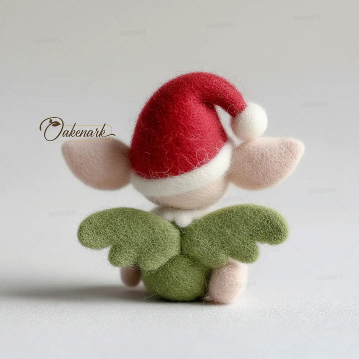 Small felt fairy figurine with a red cap on a light gray background