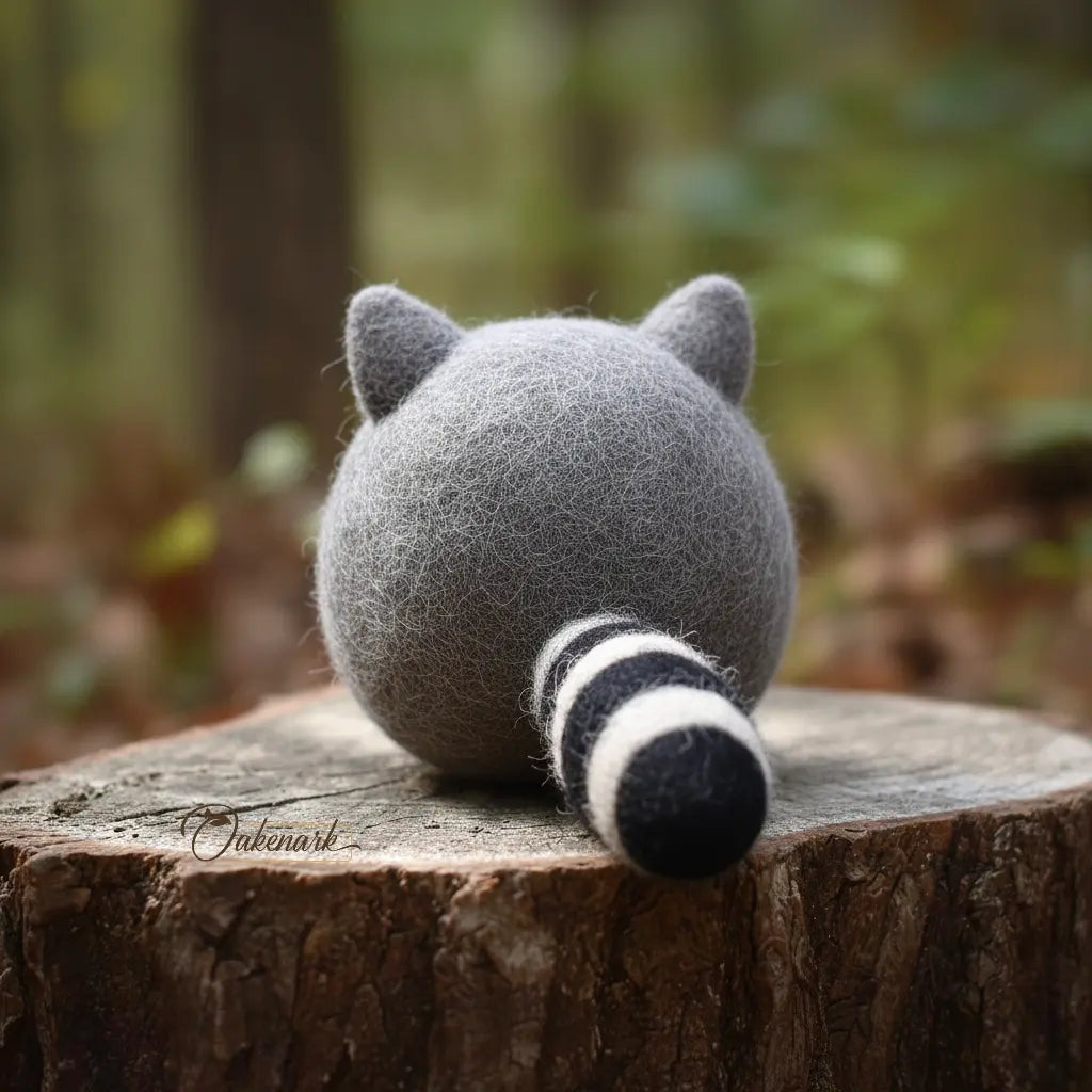 Plush raccoon toy on a wooden stump with a blurred forest background