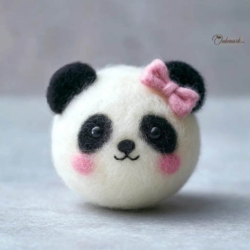 Felt panda toy with a pink bow on a light gray background