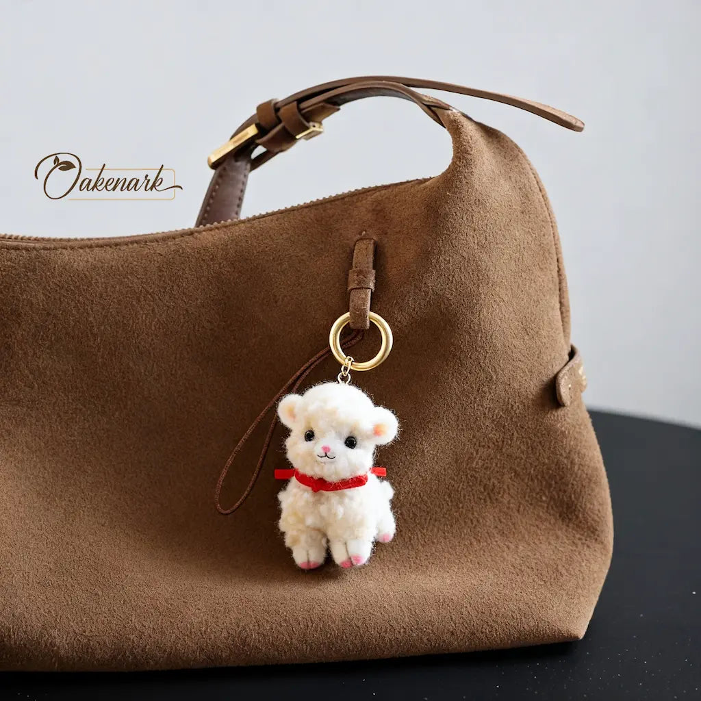 Brown handbag with a white fluffy keychain on a black surface