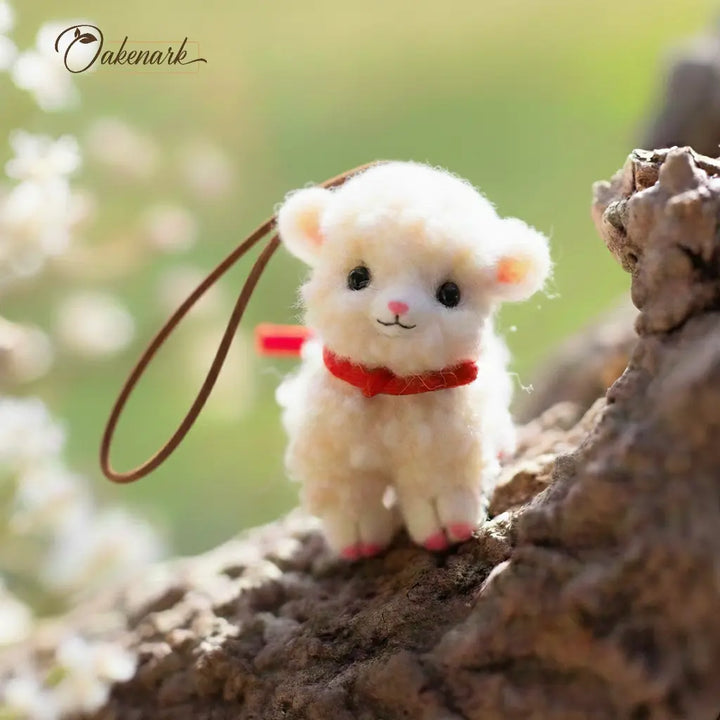 Small plush toy sheep with a red collar on a natural background