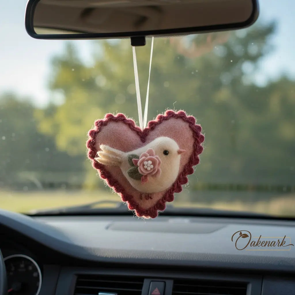 Heart-shaped car hanging ornament with a bird design on a car dashboard.
