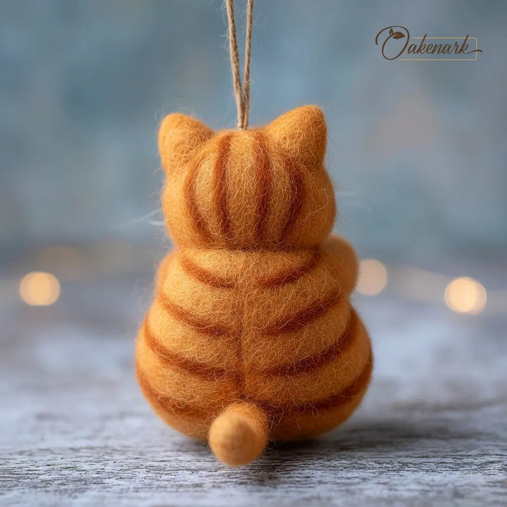 Felted orange tabby cat ornament on a blurred background
