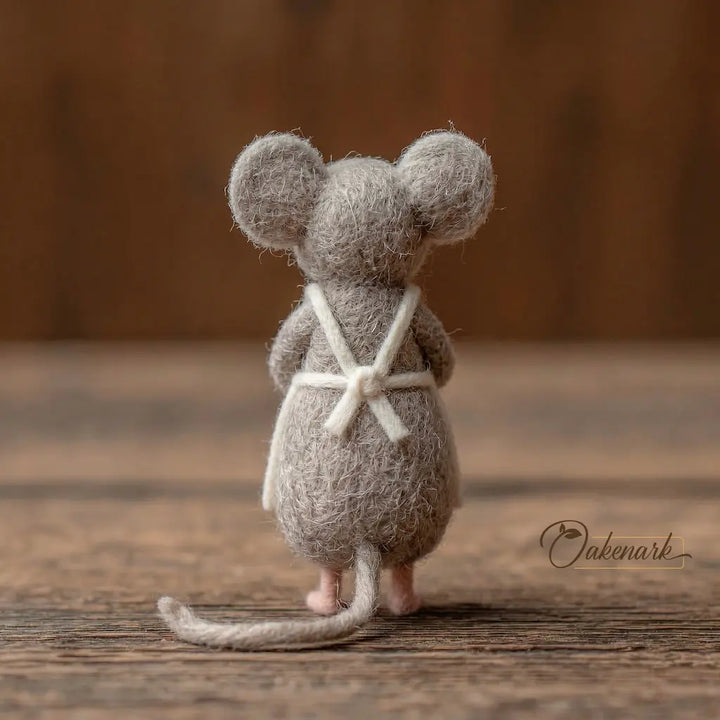 Stuffed mouse toy with a white bow tie on a wooden surface, branded &