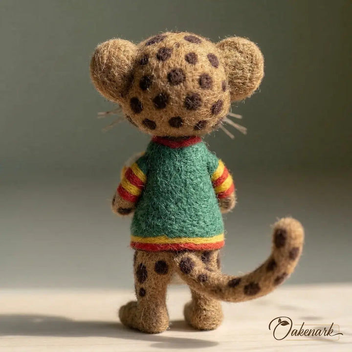 Stuffed toy leopard wearing a colorful sweater on a neutral background