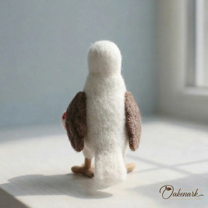 Stuffed penguin toy from behind on a light surface with a blurred background