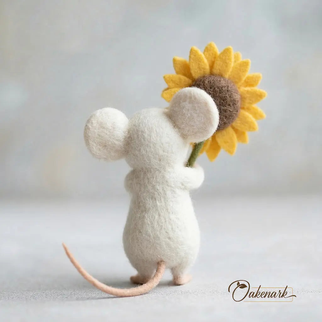 Stuffed mouse toy holding a sunflower against a light background