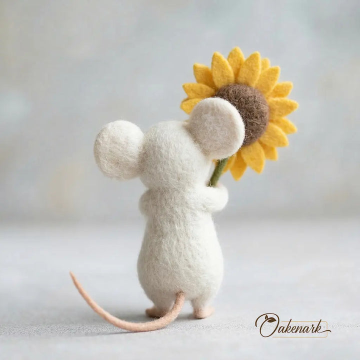 Stuffed mouse toy holding a sunflower against a light background