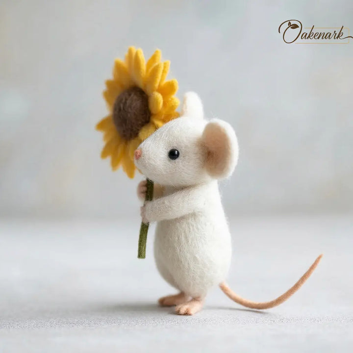 Stuffed mouse holding a sunflower against a light background