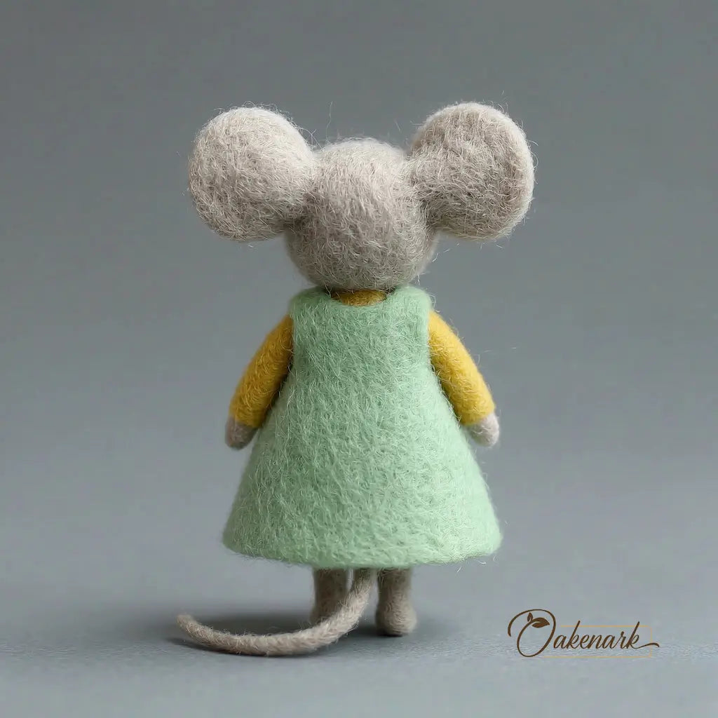 Toy mouse in a green dress with a gray background
