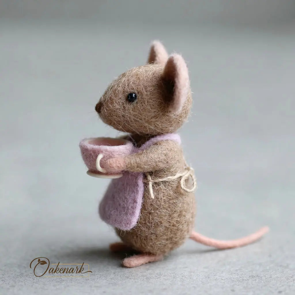 Textile mouse holding a small bowl on a neutral background