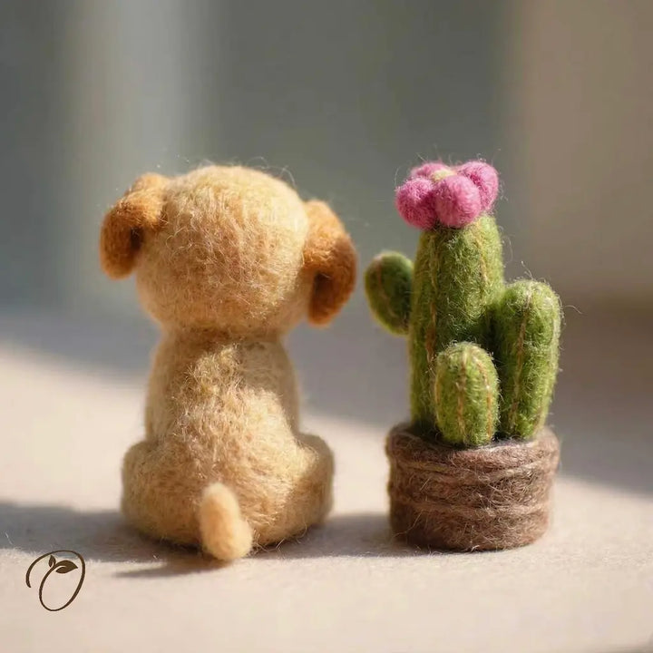 Felted toy dog and cactus on a neutral background