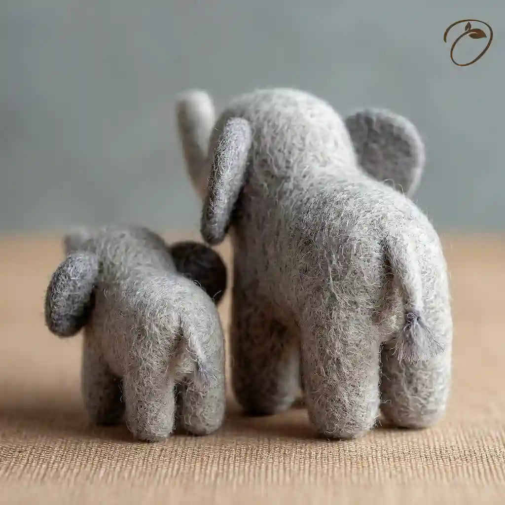 Two small gray elephant toys facing each other on a textured surface with a neutral background.