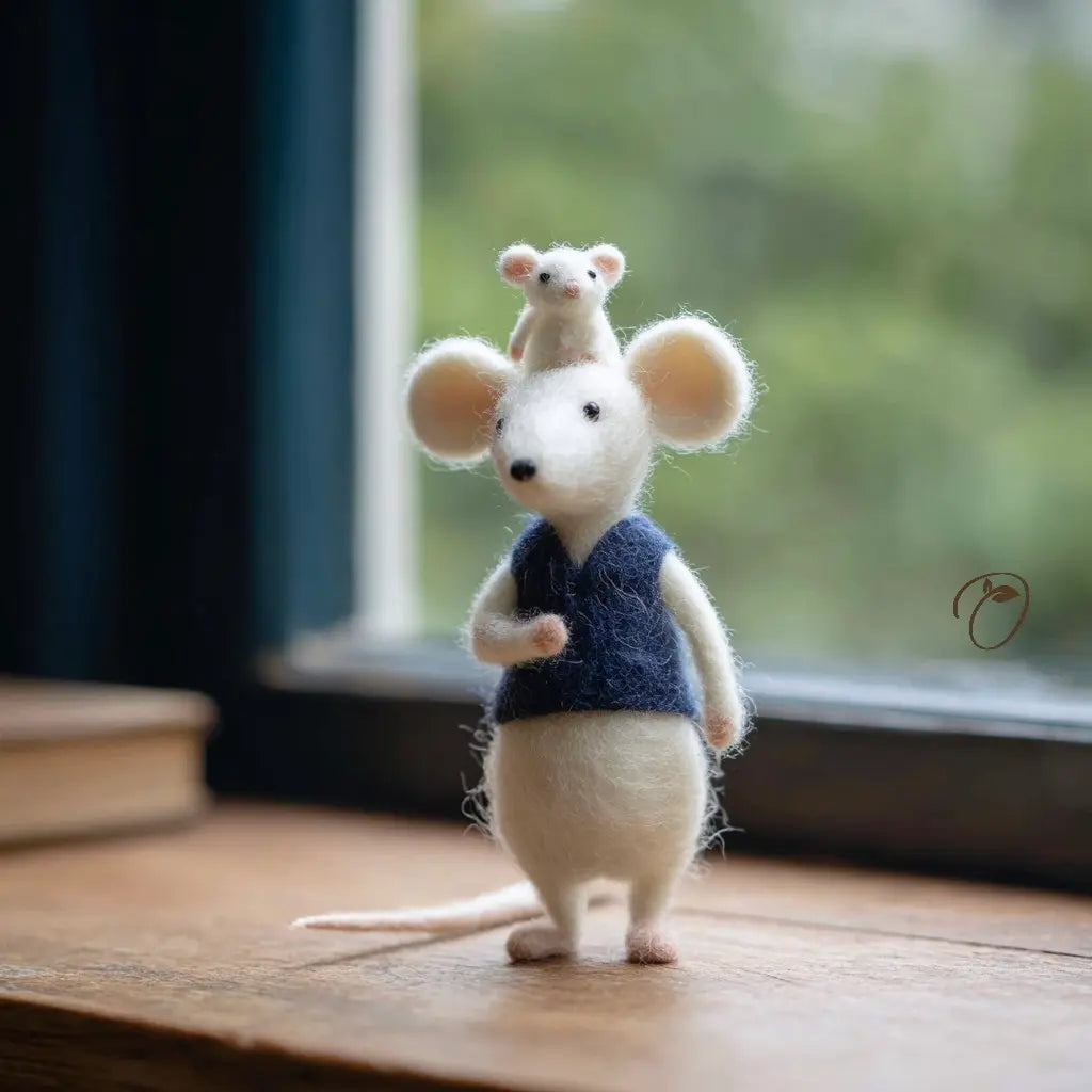 Two needle-felted mice, one standing and one sitting on top of the other, on a wooden surface with a blurred natural background.