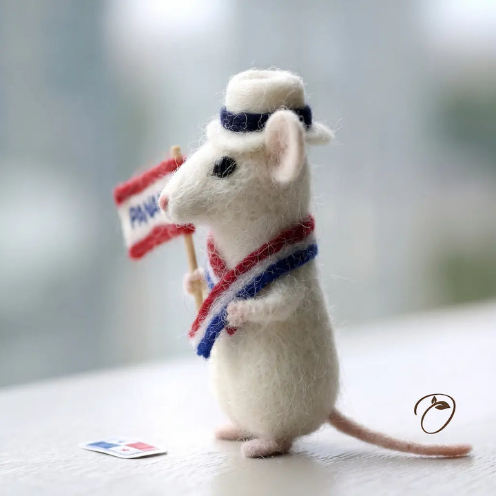 Stuffed mouse toy holding a small flag with a blurred background