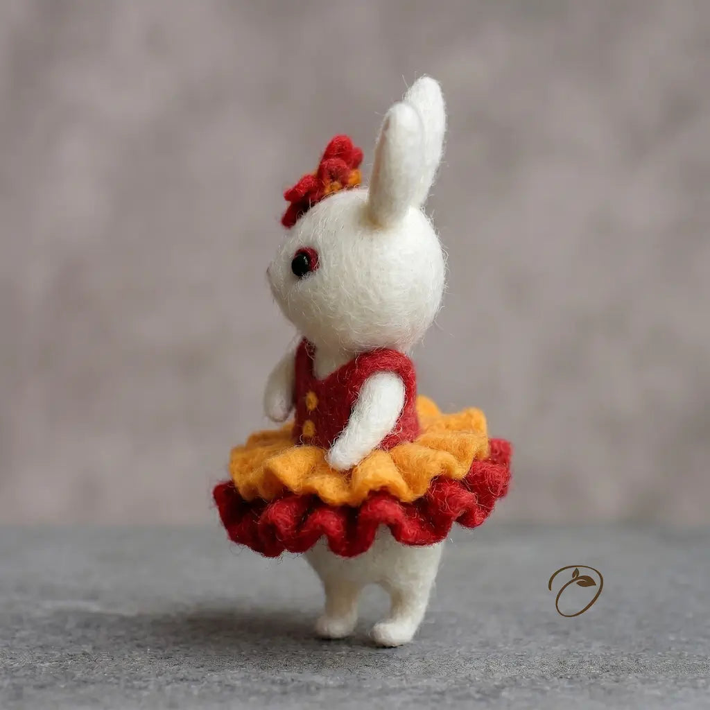 White rabbit toy with a red and yellow dress on a gray background