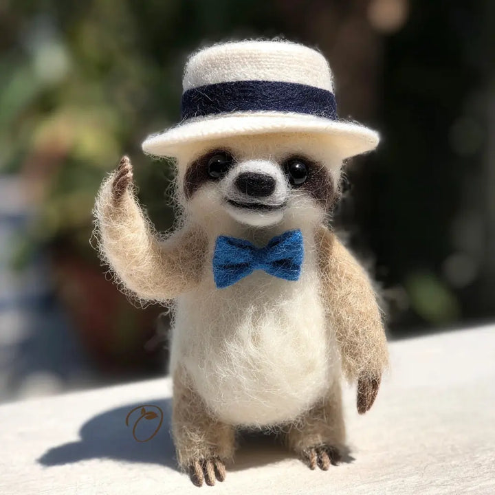 Stuffed meerkat toy wearing a hat and bow tie with a blurred natural background