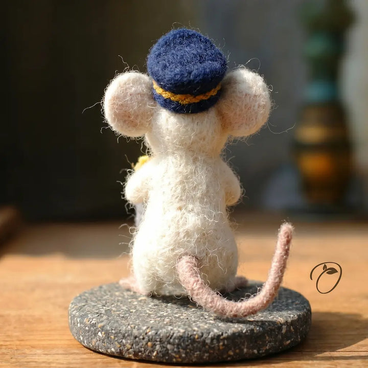 Textured mouse figurine wearing a blue cap on a wooden surface