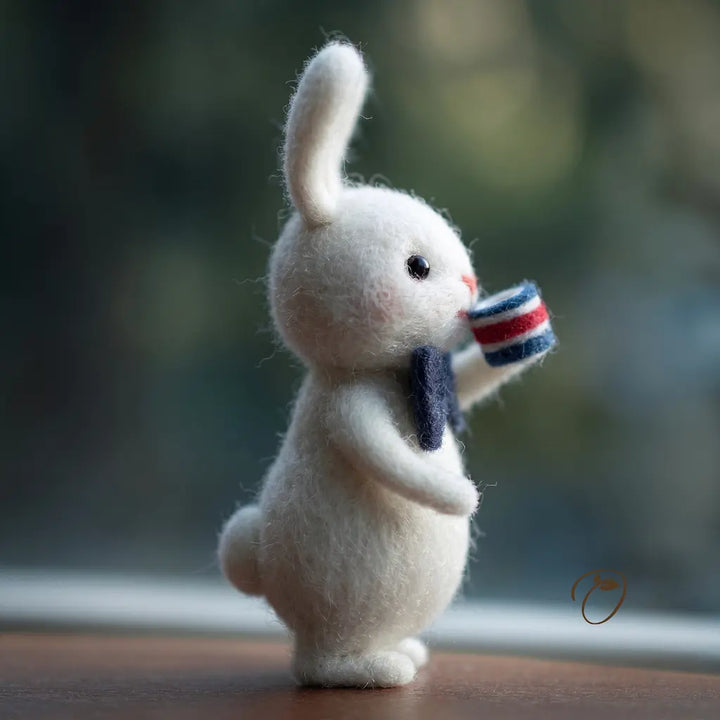 White rabbit figurine holding a small flag against a blurred natural background
