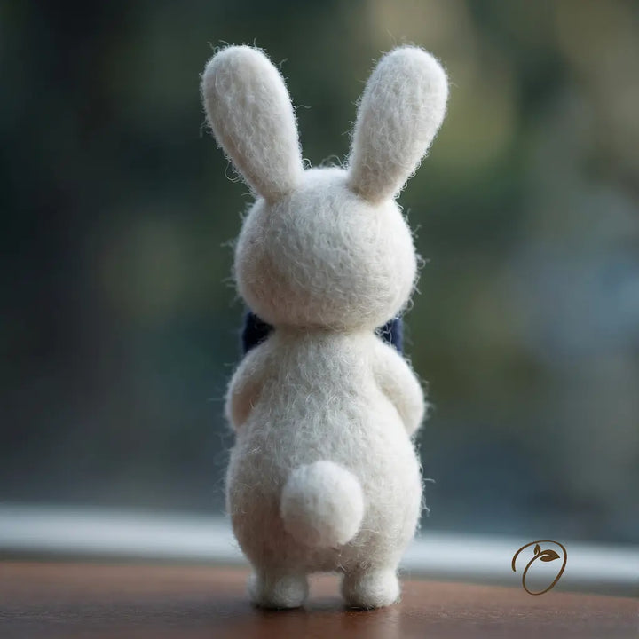 White rabbit plush toy on a wooden surface with a blurred natural background