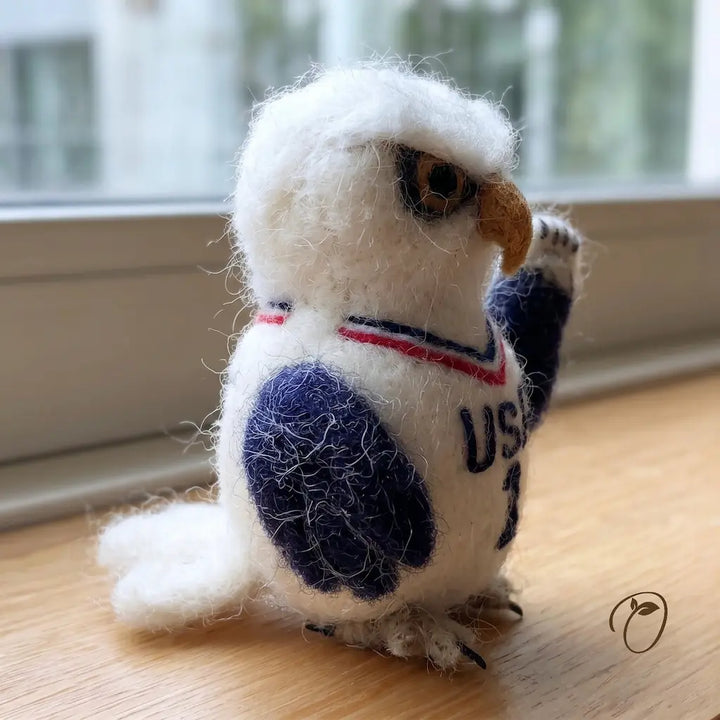 Stuffed toy owl wearing a sweater with &
