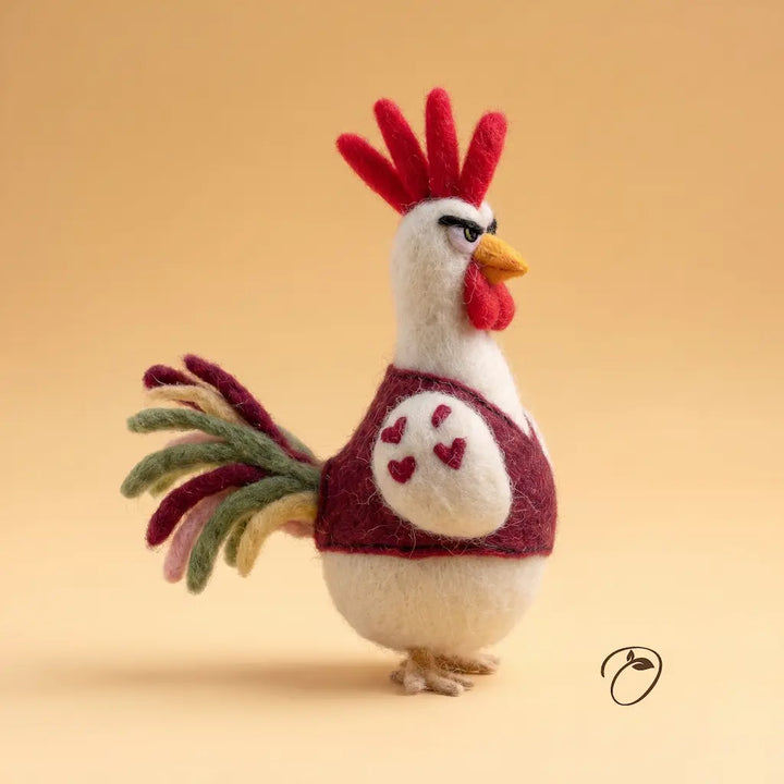 Felted rooster figurine with red comb on a beige background