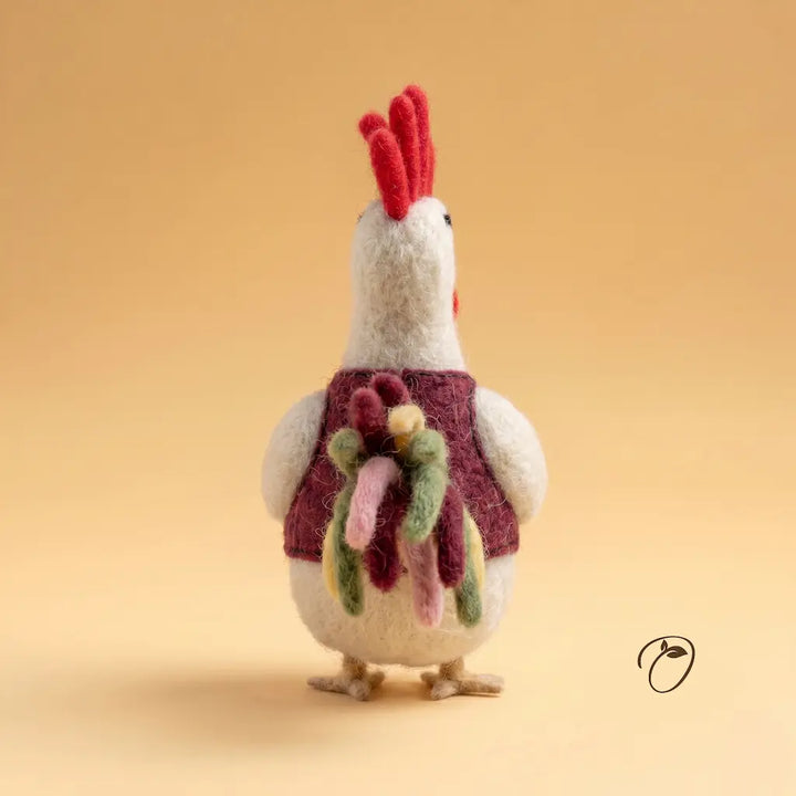Knitted rooster toy with a colorful scarf on a beige background