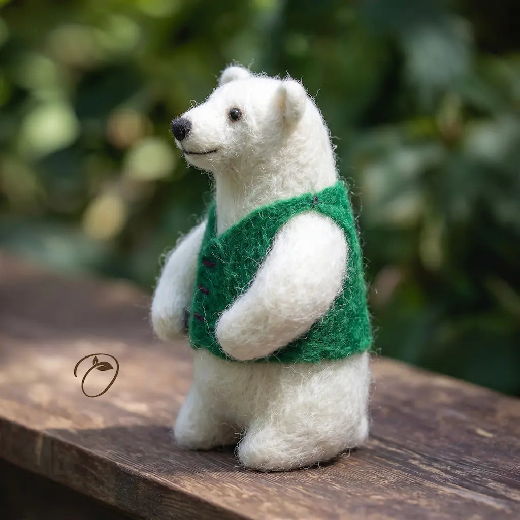 White teddy bear wearing a green vest on a wooden surface with a blurred natural background