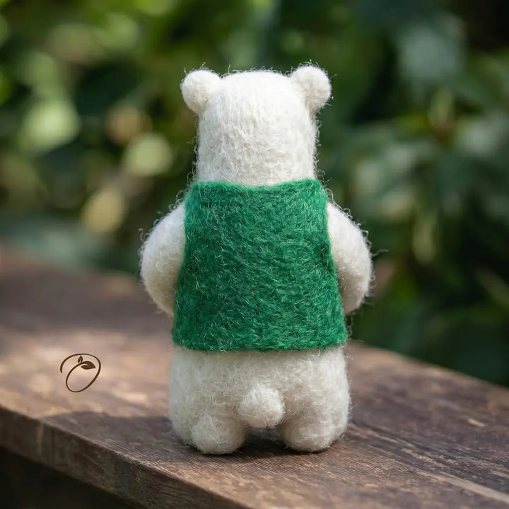 White bear plush toy with a green backpack on a wooden surface with a blurred natural background