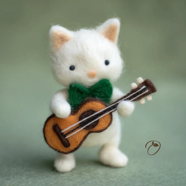 White cat figurine playing a small guitar on a light green background