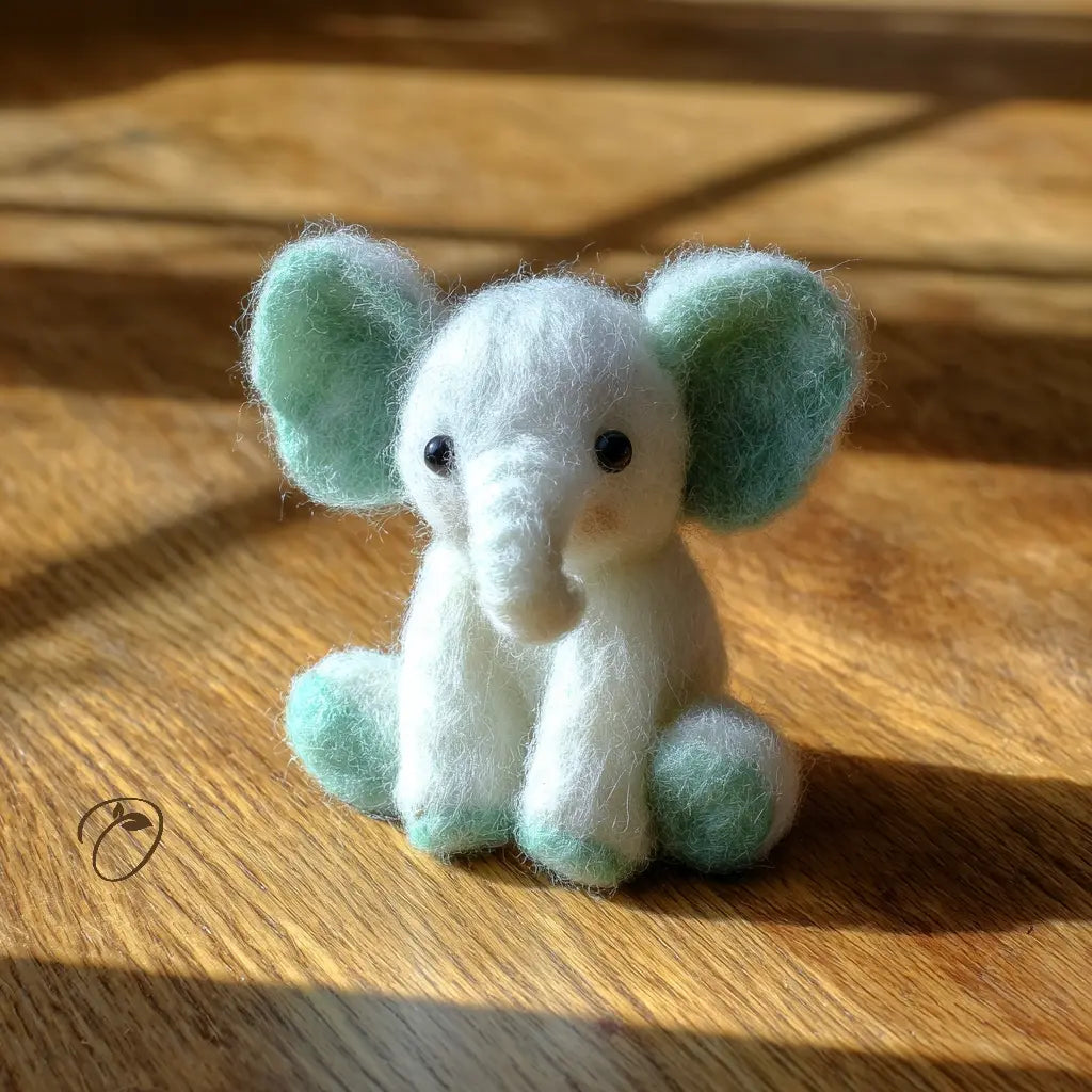 Small felt elephant toy on a wooden surface