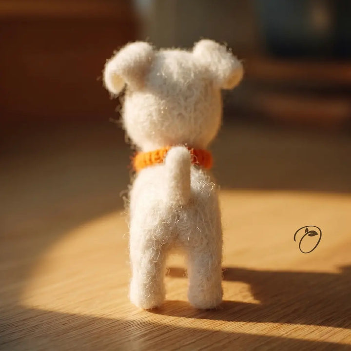 Small white teddy bear with an orange collar on a wooden surface with warm lighting.