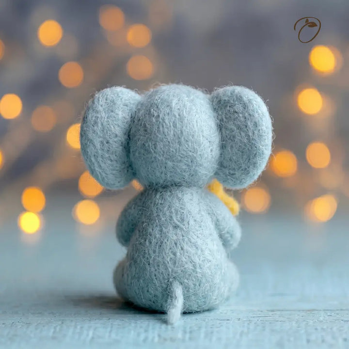 Small blue elephant toy with a blurred bokeh background