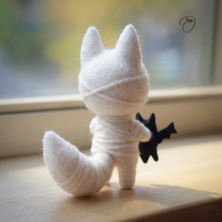White plush toy fox with black tail on a wooden surface