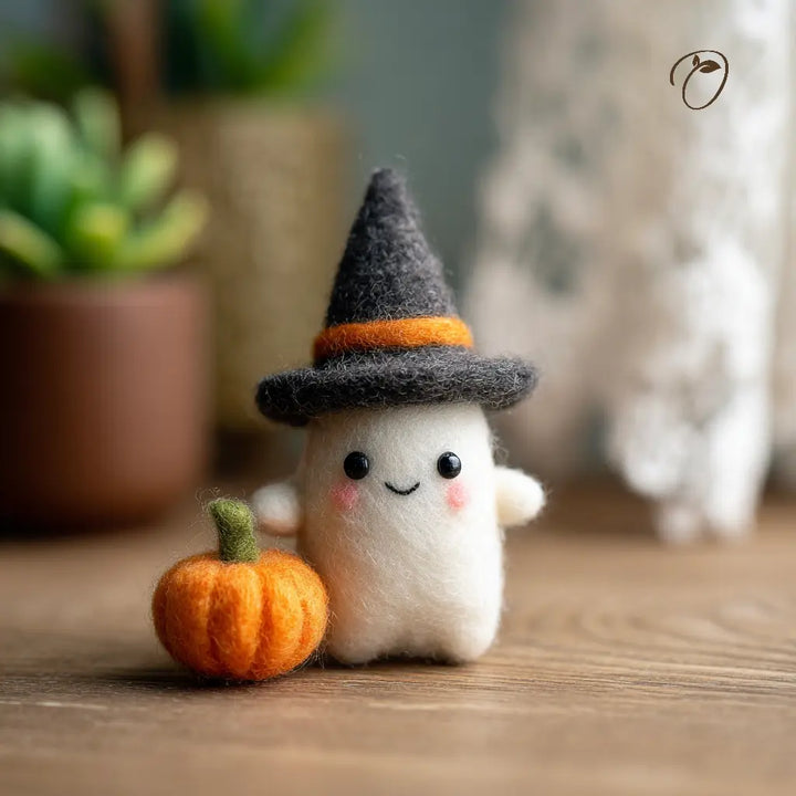Small plush ghost with a witch hat and pumpkin on a wooden surface