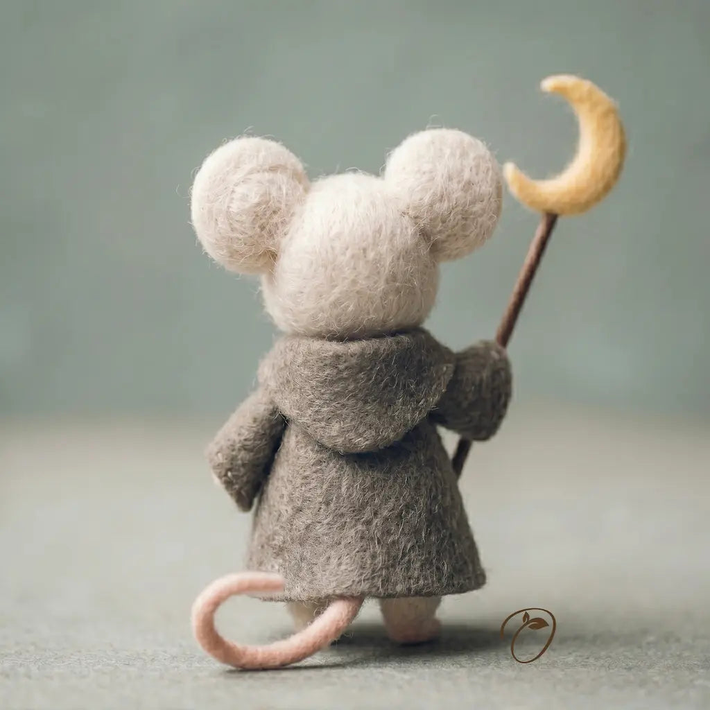 Small plush mouse toy wearing a coat and holding a crescent moon staff against a plain background