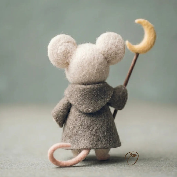 Small plush mouse toy wearing a coat and holding a crescent moon staff against a plain background
